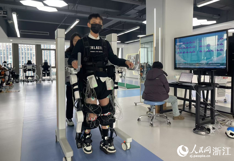 研发人员正在对外骨骼机器人进行测试。人民网记者 王丽玮摄